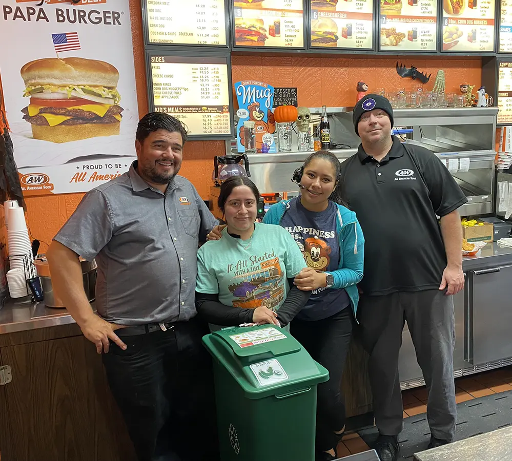 4 staff at A&W stand in front of their compost cart