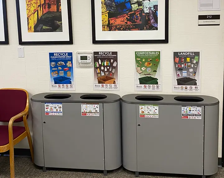 An office recycling station with MSS posters above each container