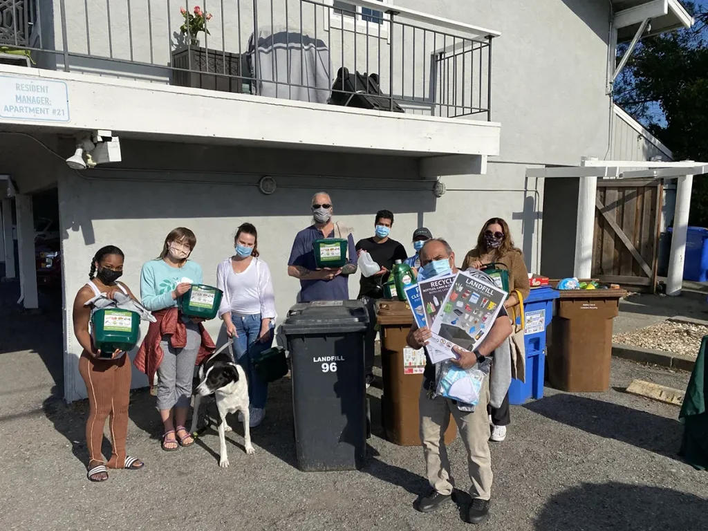 Residents of a multifamily unit pose with their compost buckets during a training