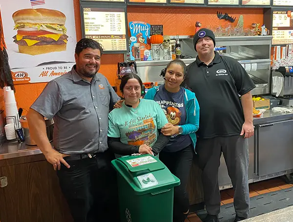 4 staff at A&W stand in front of their compost cart