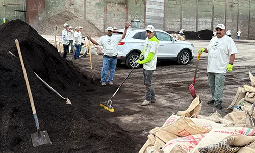 MSS Workers in white shirts & hats with shovels stand in front of a compost pile at Marin Sanitary Service.
