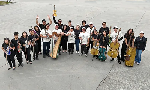 The Recycled Orchestra with all their instruments pose for a group picture.