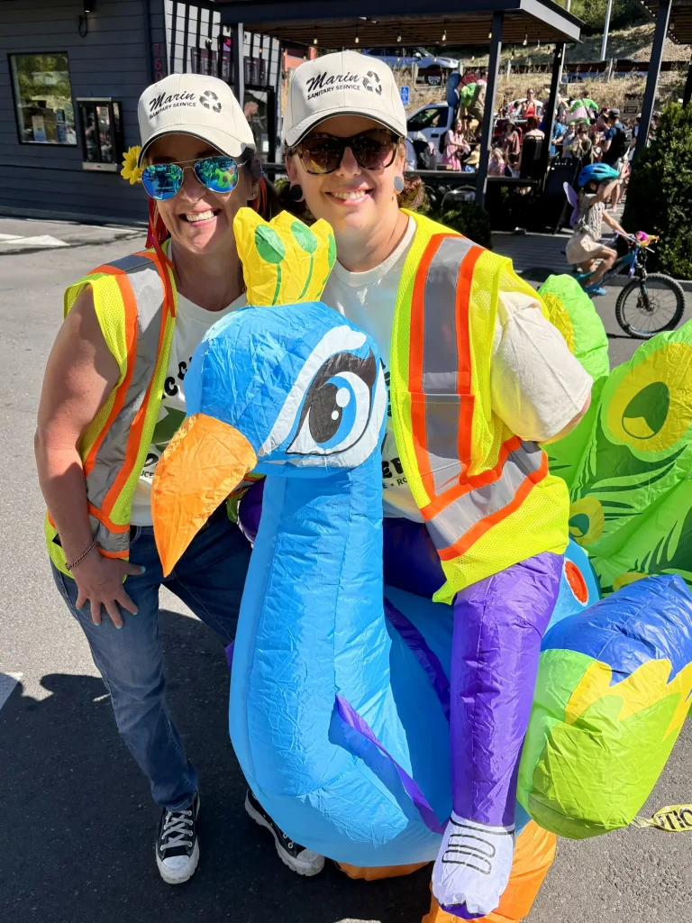 2 MSS employees in yellow jackets walk in the Fairfax Festival parade 2026