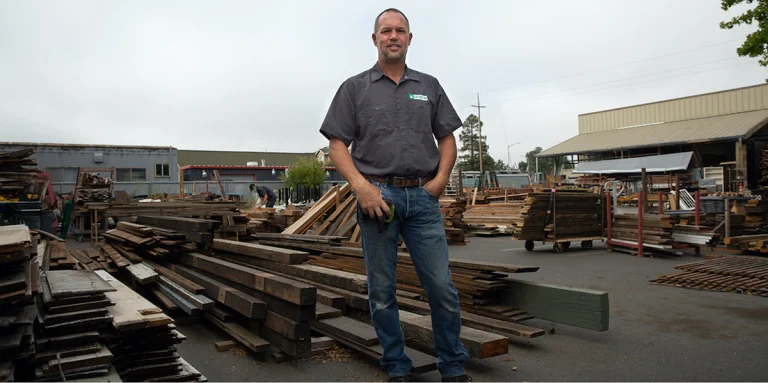 A man stands in front of reconstruction materials