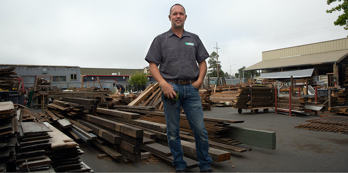 A man stands in front of reconstruction materials